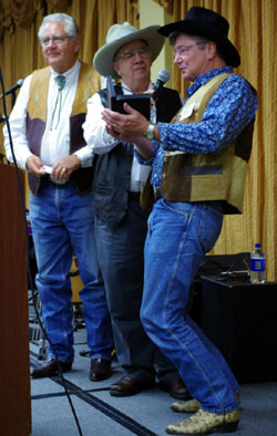 Randy Boone accepts his “Gathering of Guns 3” from emcee John Buttram and festival co-sponsor Ray Nielsen.