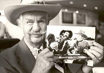 Tex Ritter sidekick Slim Andrews holds up a photo of he and Tex in their younger film-making days.