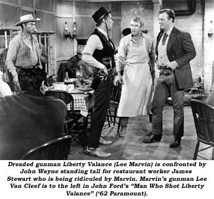 Dreaded gunman Liberty Valance (Lee Marvin) is confronted by John Wayne standing tall for restaurant worker James Stewart who is being ridiculed by Marvin. Marvin's gunman Lee Van Cleef is to the left in John Ford's "Man Who Shot Liberty Valance" ('62 Paramount).