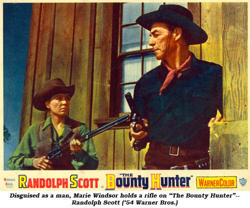 Disguised as a man, Marie Windsor holds a rifle on "The Bounty Hunter"--Randolph Scott ('54 WB).