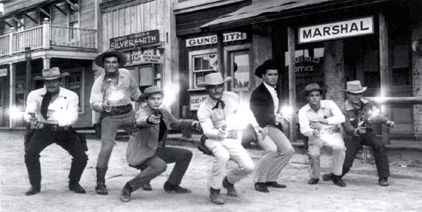 The Warner Bros. cowboys pose on lot: Wayde Preston, Ty Hardin, Jack Kelly, John Russell, James Garner, Peter Brown, Will Hutchins.