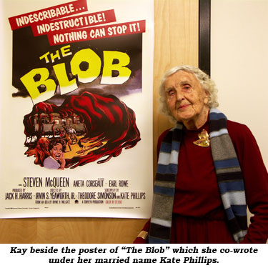 Kay beside the poster of "The Blob" which she co-wrote under her married name Kate Phillips.