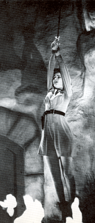Serial scene showing Nyoka hanging by her arms above flames.