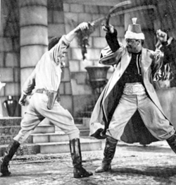 Serial scene showing Clayton Moore sword fighting with Arab.