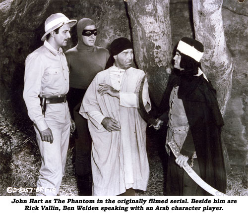 John Hart as The Phantom in the originally filmed serial. Beside him are Rick Vallin, Ben Welden speaking with an Arab character player.