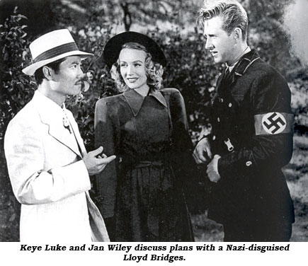 Keye Luke and Jan Wiley discuss plans with a Nazi-disguised Lloyd Bridges.