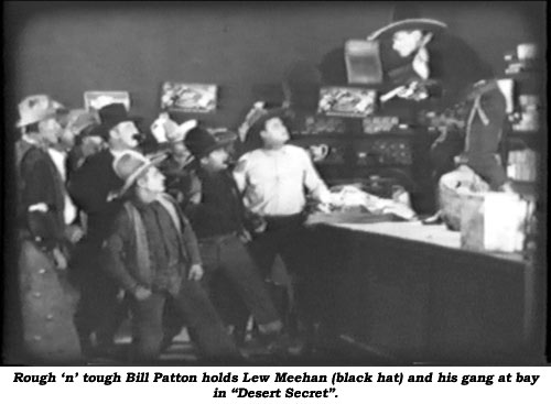 Rough 'n' tough Bill Patton holds Lew Meehan (black hat) and his gang at bay in "Desert Secret".