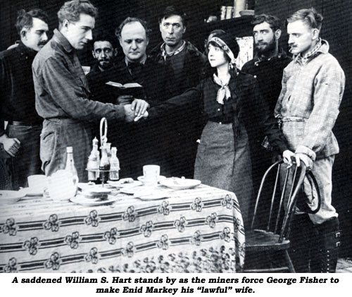 A saddened William S. Hart stands by as the miners force George Fisher to make Enid Markey his "lawful" wife.