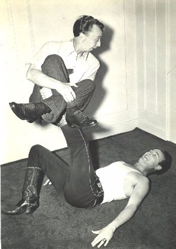 Roy Rogers gets a little "exercise" from contortionist Emmett Oldfield