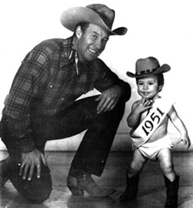 Bill Elliott was in Cisco, TX, just before Christmas 1950 to represent BACK IN THE SADDLE horseman magazine in thier annual Christmas parade. While in Cisco Bill posed for the above two pictures with 14 month old Bonnie Jo Steffen, editor Randy Steffen’s daughter. The photo on the left was used for the cover of BACK IN THE SADDLE (1/51) and the other was used in the interior of the magazine. The photo below was taken in the offices of BACK IN THE SADDLE.