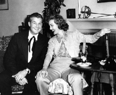 George Reeves and Virginia Grey enjoy a laugh together at a party. Would be interesting to know why Virginia is holding her hand over the candle.