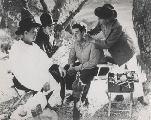 Smiley Burnette and Bob Livingston get made up for a scene in Republic's "Pride of the Plains" ('44) while Harry Woods visits the set from another picture as he was not in "Pride of the Plains". Livingston, who wore a white hat in the short-lived series, had to don his old Stony Brooke costume...black hat and two-tone pants...for part of the film to match stock footage from "Hit the Saddle". (Thanx to John Brooker.)