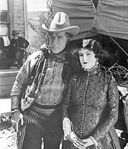 William S. Hart and leading lady Barbara Bedford pose for the camera while making “Tumbleweeds” (‘25).