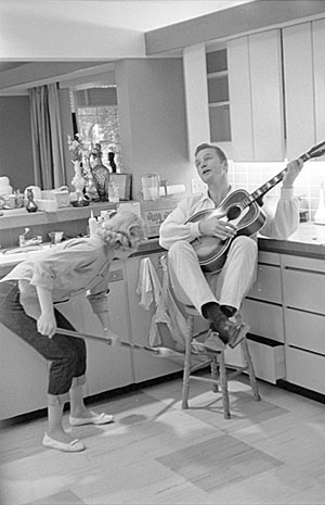 Not sure what’s going on here! Eric Fleming strums a guitar while Carol Byron sweeps the floor beneath him in a very domestic scene. Problem is, Fleming was never married, but Byron did make an episode of “Rawhide”, “The Woman Trap”. 