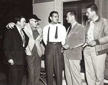 (L-R) Thomas Mitchell, John Ford, Clark Gable, Robert Montgomery and John Wayne have a chat while Ford, Montgomery and Wayne were all making “They Were Expendable” in 1945. 