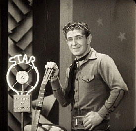 Bob Steele on an early “Voice of Hollywood” talkie short. (Photo thanks to Leonard Maltin.) By the way, Bob Steele sings in six B-Westerns, including his first three talkies. Here’s the list: “Near the Rainbow’s End” (‘30 Tiffany), Bob and Perry Murdock sing “Ragtime Cowboy Joe” and another song. (Note: this is five years before Gene Autry became “the” singing cowboy.) “Oklahoma Cyclone” (‘30 Tiffany) Bob sings several songs. “Land of Missing Men” (‘30 Tiffany) Bob sings “Prairie’s End” twice. “Ridin’ Fool“ (‘31 Tiffany) Bob sings “I Fell in Love With You, Can’t You Fall in Love With Me?” “Gallant Fool” (‘33 Monogram) Bob sings “The Girl That I Love”. “Trailing North” (‘33 Monogram) Bob sings “I’m Headin’ Home”. 