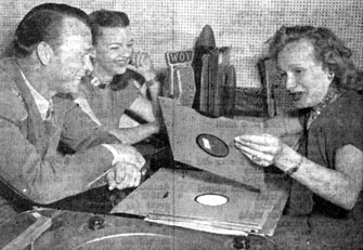 Roy Rogers and Dale Evans present their latest 78rpm record for consideration to disc jockey Rosalie Allen of WOV radio New York City. 