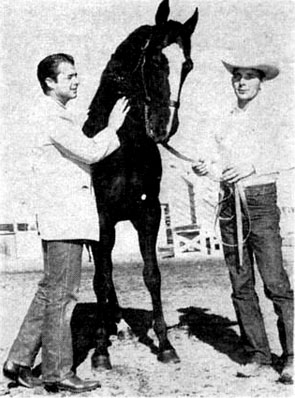 Audie Murphy looks over Mackay Boy, a recent edition to his Quarter racing stable. Trainer Dallas Clark holds the halter. 
