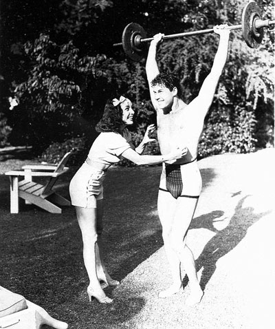 A pre-Lone Ranger Clayton Moore seems to be saying to Lupe Velez, “Don't tickle me while I've got this barbell.” (Thanx to John Bickler.)