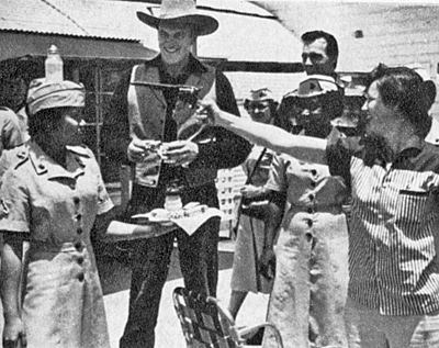 James Arness was Grand Marshal of the town’s annual rodeo in El Toro, CA. Invited to lunch at Toro Marine Base, he watches as Private “Monty” Montgomery displays her female marksmanship. 