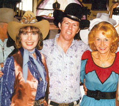 Stuntman Neil Summers surrounded by beauty--Penny Edwards (left) and Vera Hruba Ralston (right) at a Monte Hale birthday party in 1979.