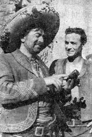 Rico Alaniz (left) points out the notches on the grip of his gun to Robert Loggia who plays the lead in Disney’s “Nine Lives of Elfego Baca”. Photo taken on location in Cerrillos, New Mexico, in June 1958.