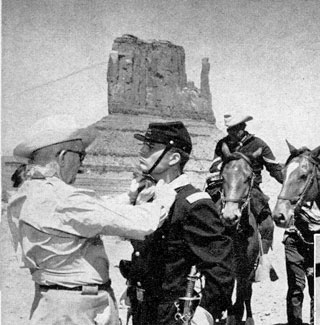John Ford adjusts Pat Wayne’s wardrobe before a “Searchers” scene in Monument Valley.