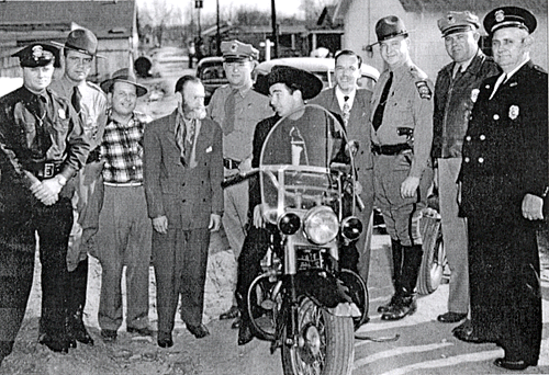 Not sure exactly what’s going on here, but Fuzzy St. John and Lash LaRue seem to be mingling with officers of the Law. 