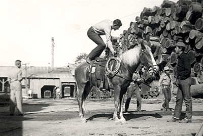 Stuntman Boyd Stockman shows how a running mount is done during the making of a Jimmy Wakely Monogram B-Western. That’s Wakely in the background. 