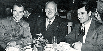 At dinner, Roy Rogers and Ray Whitley flank an unidentified friend circa 1940. 