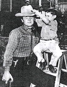 Audie Murphy has his hat adjusted by young son Terry. 