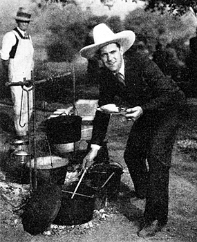Ken Maynard helps himself to some barbeque at a chuck wagon dinner he hosted in April 1930. 