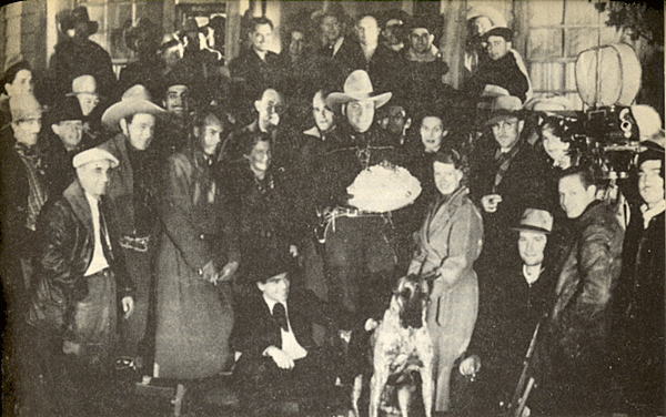 Buck Jones’ birthday party on December 12, 1937 at Universal Studios. Wife Odille Jones is in front holding their Great Dane. Maxine Jones, Buck’s daughter, is behind Odille. Director Les Selander is in front in the long overcoat. The rest are cast and crew members of Buck Jones’ production company. 