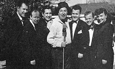 Smiley Burnette with the singing Whipoorwills who starred with Smiley on his transcribed 15 minute RadiOzark programs. (L-R) Chief announcer/assistant program director Joe Slattery, and Whipoosrwills, Arthur Dalton, Dusty Rhoads, Smiley, Roy Lanham, Gene Monbeck and Sweet Georgia Brown. 