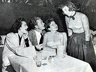 Jeff Donnell (standing) speaks with Barbara Hale, Bill Williams and Coleen Gray
at a Hollywood dinner party. 