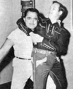 Gene Autry indulges in a bit of horseplay with his physical instructor.