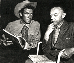 Jock Mahoney goes over a "Range Rider" script in 1954 with adirector on the series.
