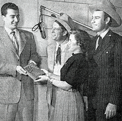 COUNTRY SONG ROUNDUP columnist and KFVD radio DJ George Sanders accepts a gold plaque in 1950 from KFI-TV reporter Gloria Grant. The award, known as 'The Western Life' was presented every year by Smokey Rogers and Tex Williams to the person who had done the most to encourage Western music in America. 