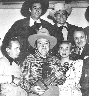 Producer Henry MacRae receives an award for 30 years in the business while on the set of “Riders of Death Valley” serial (‘41). (L-R) Director Ray Taylor, Glenn Strange, Buck Jones, Jeanne Kelly, Monte Blue.