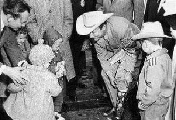 Roy Rogers shows his boots to a group of young fans in Nashville, Tennessee.