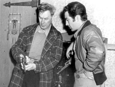 William S. Hart gives a little firearm instruction to Robert Taylor during the making of “Billy the Kid” (‘41 MGM).
