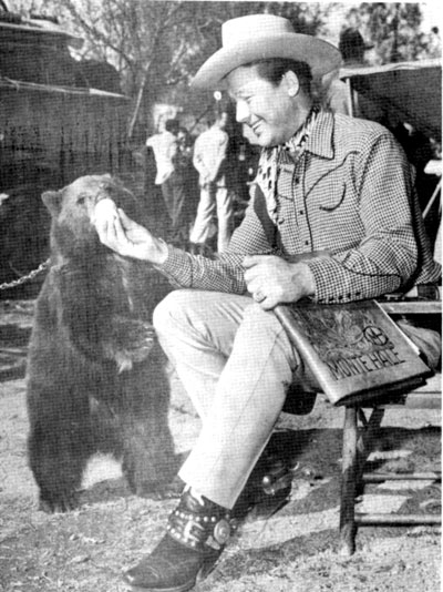 During a break in the filming of “Home on the Range”, Monte Hale takes an opportunity to feed the bear. Note the leather script cover under Monte's arm.