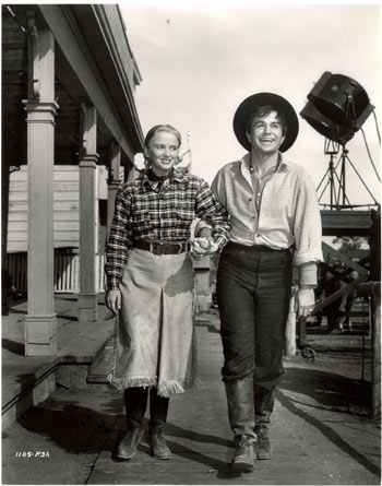 Jeanne Kelly and Noah Beery Jr. take a stroll on the Universal back lot between scenes of “Riders of Death Valley” (‘41).