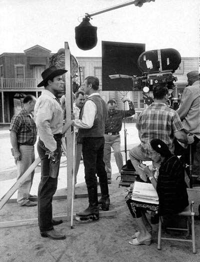Clint “Cheyenne” Walker on the Warner Bros. back lot. That’s Clyde Howdy, Clint’s stand-in and a sometime actor, looking the other way. Note the little old lady script supervisor seated in front of Clint.