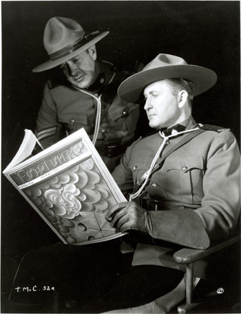 Tim McCoy and another actor take a break from filming “Fighting Shadows” (‘35 Columbia) to glance at the February ‘35 copy of FORTUNE magazine.