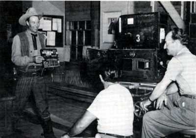 Bill Elliott holds a slate for the next scene of “The Fabulous Texan” (‘47) for Republic cinematographer Jack Marta.