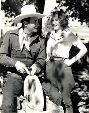 Ray “Crash” Corrigan instructs leading lady June Martell how to sharpen a knife during a break from “Wild Horse Rodeo” (‘37 Republic).