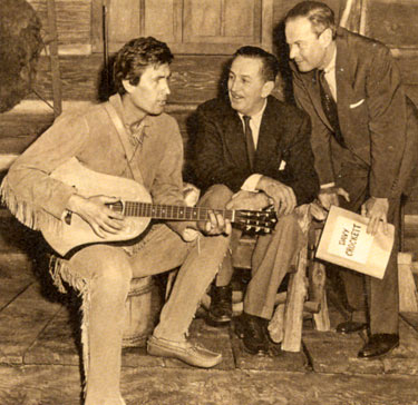 Fess Parker tunes up his guitar for producer Walt Disney and director Norman Foster of 1955’s “Davy Crockett, King of the Wild Frontier”.