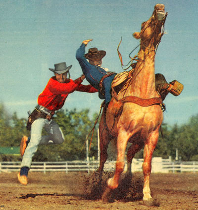 All these photos are from PARADE, the Sunday newspaper supplement, from March 22, 1953. The color photo was on the cover showing Jock Mahoney bulldogging Dick Jones from his horse. The first strip of photos shows Dickie doing a croupier mount and Jocko doing a fork jump over the horse’s neck into the saddle. The second group of photos shows Jocko coming at Dickie from his left side and bulldogging him off the horse.