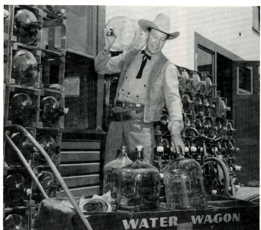 Wild Bill Elliott loads bottles onto the Republic water wagon in this publicity shot taken for "The Fabulous Texan" in 1947.